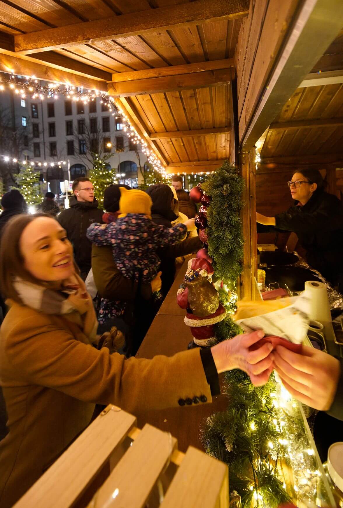 Frau erhält Bratwurst am Weihnachtsmarkt-Stand