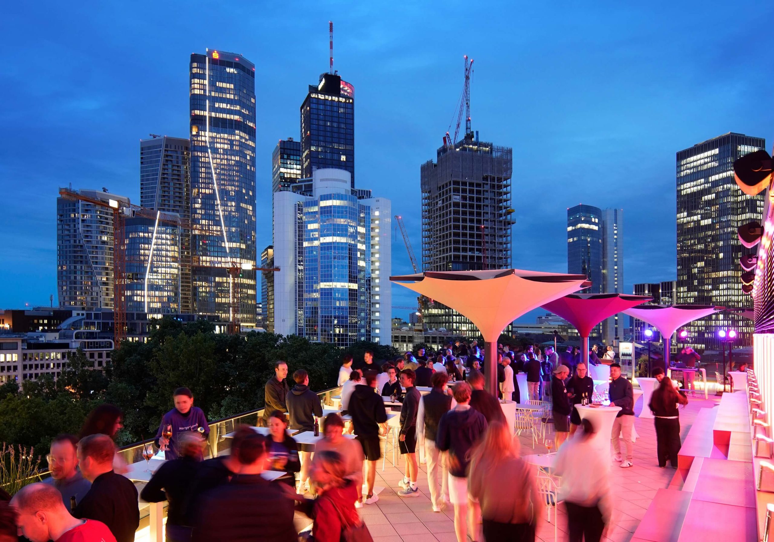 OpernTurm Dachterrasse mit vielen Menschen und Beleuchtung bei Nacht vor der Kulisse der Skyline