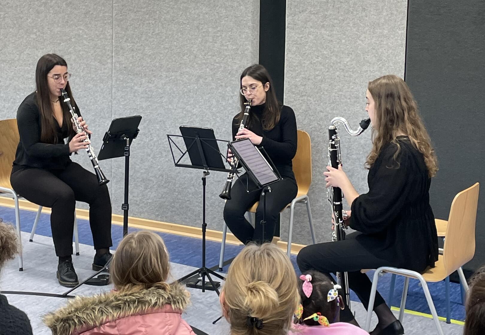 Flöten-Trio spielt vor einem kleinen Publikum